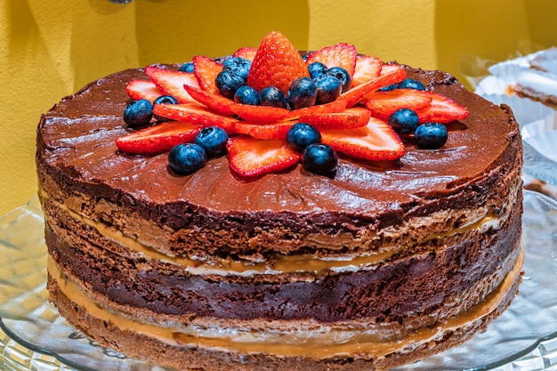 Chocolate y dulce de leche con tarta de fresas, con dulces en la mesa.