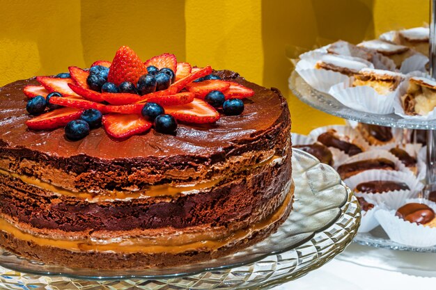 Chocolate e doce de leite com bolo de morango, com doces na mesa.