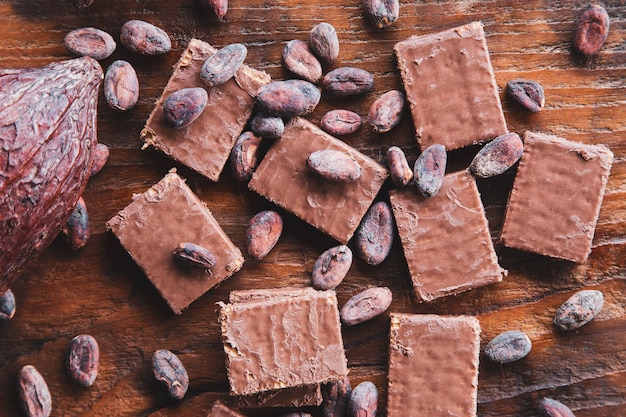 Chocolate e grãos de cacau com cacau em um fundo preto