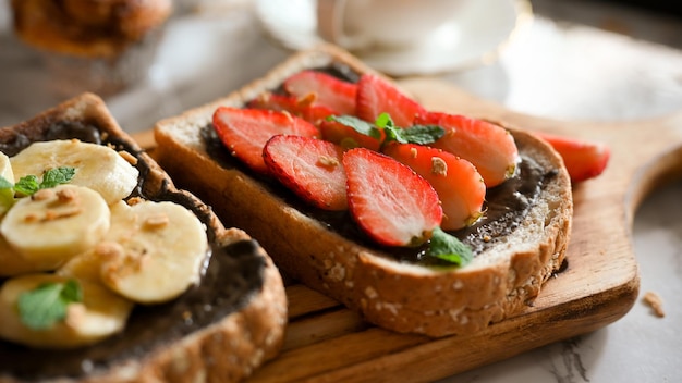 Chocolate fechado com torradas de banana e morango na placa de madeira Lanche saudável para dieta