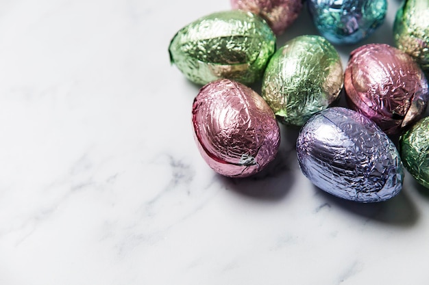 El chocolate con huevo de Pascua trata la envoltura en una lámina de color brillante sobre un fondo de mármol
