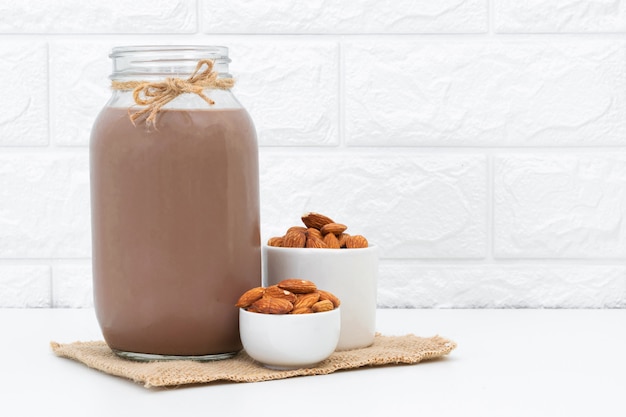 Chocolate con leche y almendras en un vaso sobre blanco