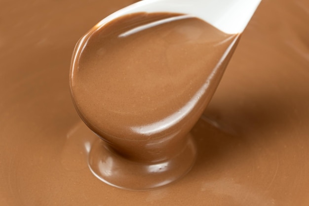 Chocolate con leche derretido derramado de una cuchara