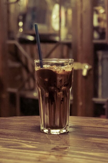 Chocolate con leche helado con cacao en un vaso alto. fondo de bebida fría de verano