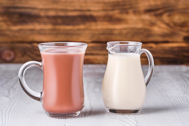 Chocolate con leche y leche de soja en mesa de vidrio