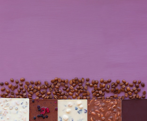 Chocolate na violeta com grãos de café. Chocolate. Barra de chocolate. Chocolate de nozes. Copie o espaço.