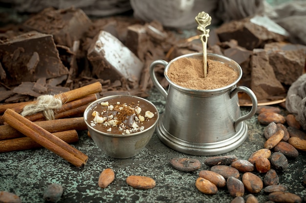 Chocolate negro en una composición con granos de cacao y nueces, sobre un fondo antiguo.