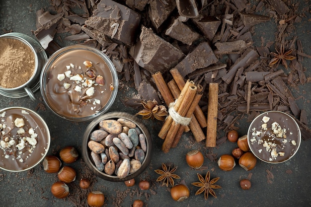 Chocolate negro en una composición con granos de cacao y nueces, sobre un fondo antiguo.