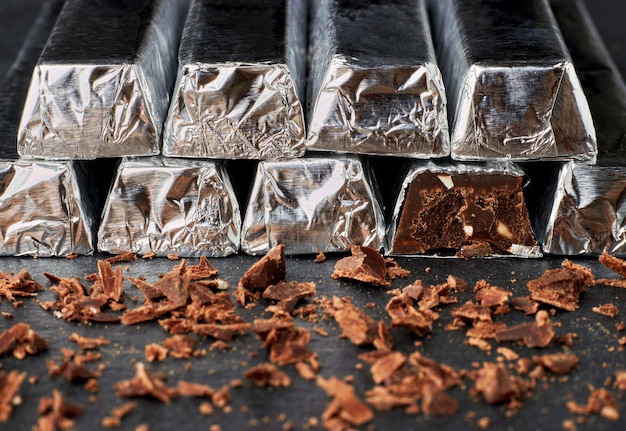 Chocolate negro con nueces picadas envueltas en papel de aluminio apiladas