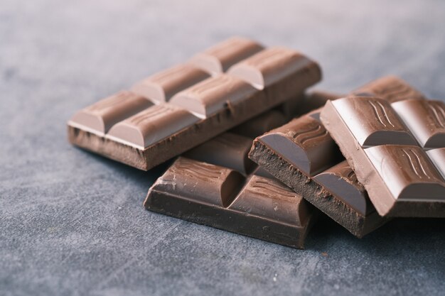 Chocolate negro en un plato sobre fondo rosa