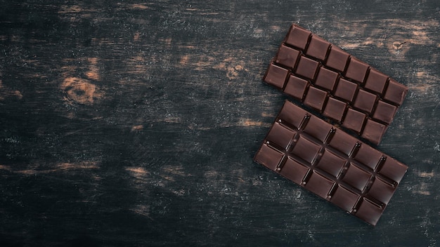 Chocolate negro sobre una mesa de madera Vista superior Copiar espacio para texto