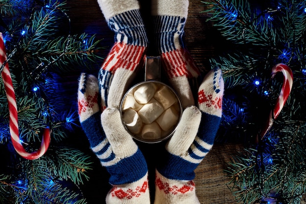 Chocolate quente caseiro de Natal com marshmallows nas mãos do homem e da mulher, vista superior