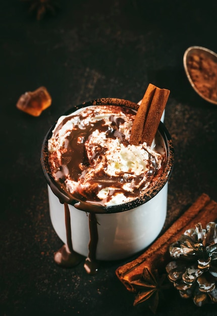 Chocolate quente com chantilly e cacau em pó em canecas de metal Inverno e outono bebida quente de Natal Espaço para cópia