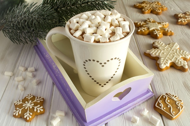 Chocolate quente com marshmallows e composição de Natal em fundo branco de madeira