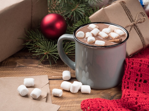 Chocolate quente com marshmallows e decoração de Natal em uma mesa de madeira. Copie o espaço.