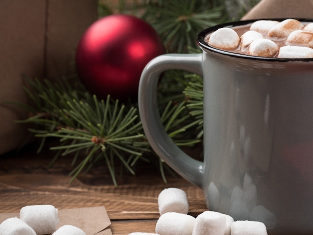 Chocolate quente com marshmallows e decoração de Natal em uma mesa de madeira. Copie o espaço.