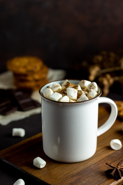 Chocolate quente com marshmallows em uma caneca branca em um enferrujado