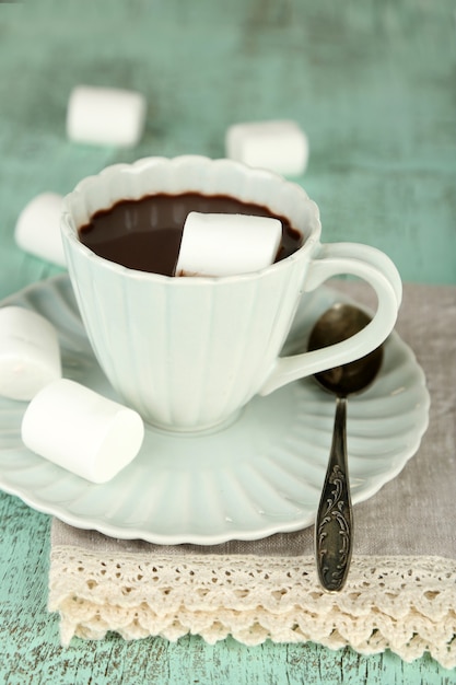 Chocolate quente com marshmallows na caneca, com fundo de madeira