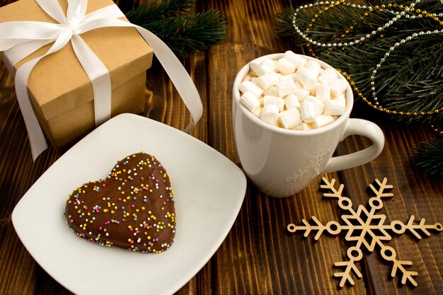 Chocolate quente com marshmallows no copo branco e composição de natal