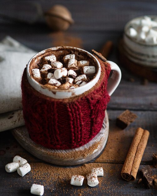 Chocolate quente com marshmallows Paus de canela e cacau Bebida quente em um fundo de madeira