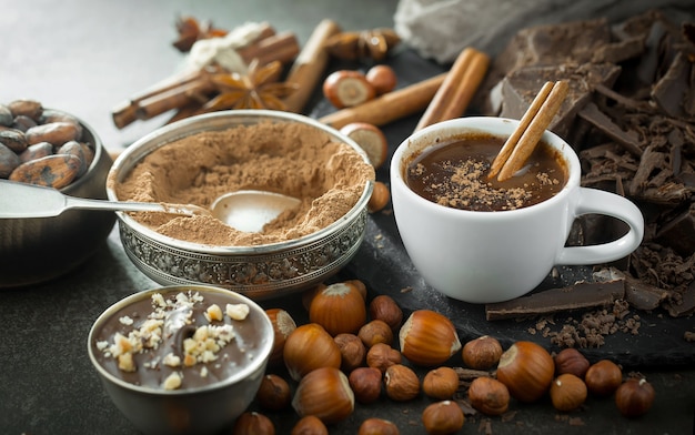Chocolate quente em um fundo antigo em uma composição com grãos de cacau e nozes.