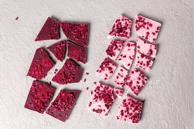 Chocolate rosa ou rubi na moda com pedaços de frutas e frutas Ver os de cima