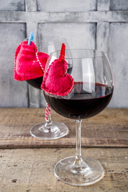 Chocolate, rosas, copos de vinho e caixa de coração na mesa de madeira