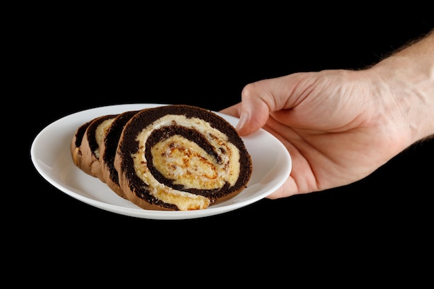 Chocolate Swiss Roll auf einem Teller in der Hand