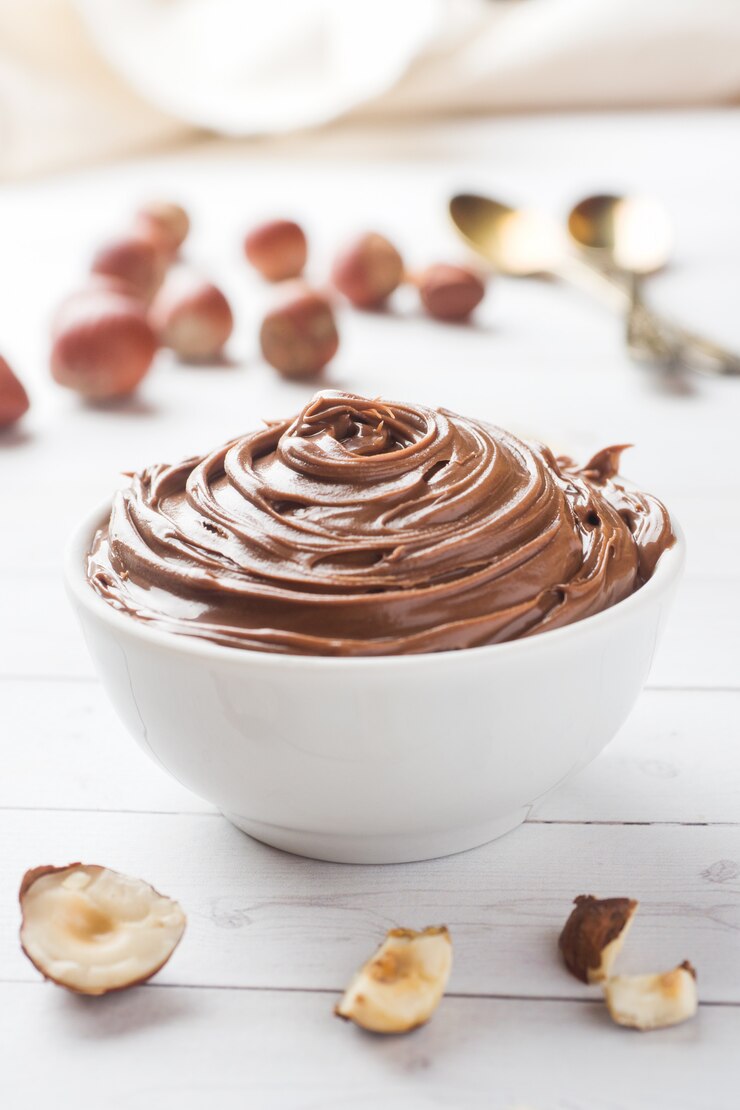 Chocolate de la tuerca del turrón en una placa en un fondo blanco con las nueces de la avellana.