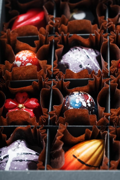 Chocolates artesanais em uma caixa. produção de produtos de confeitaria. doces coloridos, arte culinária.