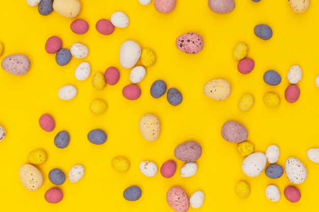 Chocolates de caramelo de huevo de Pascua sobre un fondo amarillo brillante de primavera