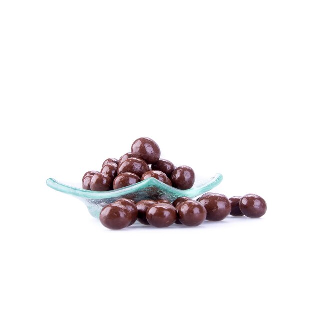 Foto chocolates en un cuenco contra un fondo blanco