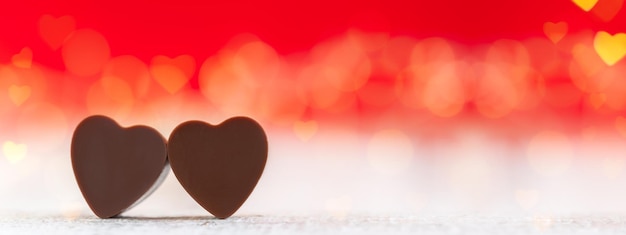 Chocolates em forma de coração em fundo vermelho com banner de cartão de feliz dia dos namorados boke