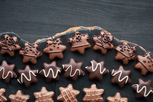 Chocolates em forma de estrela na mesa de madeira escura