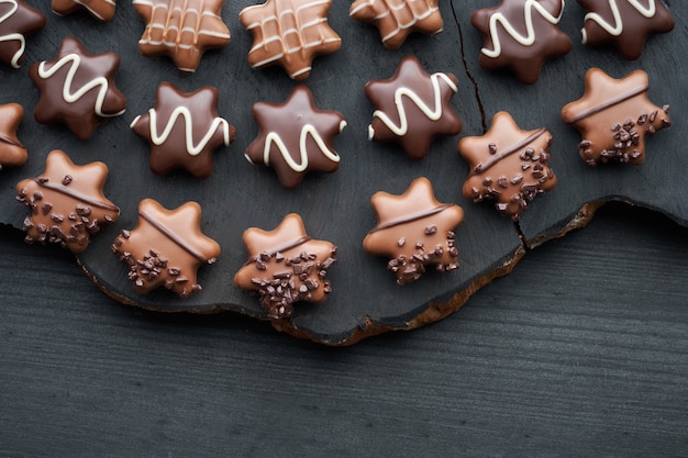 Chocolates en forma de estrella sobre fondo oscuro con textura