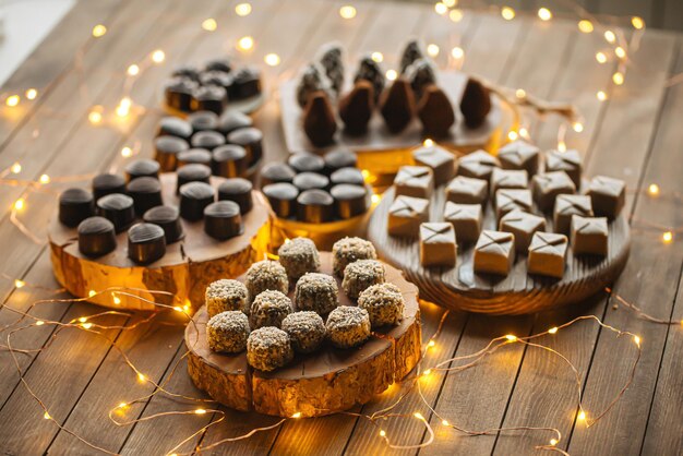 Chocolates surtidos en mesa de madera con guirnalda