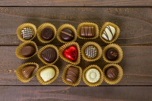 Chocolates surtidos en mesa de madera.