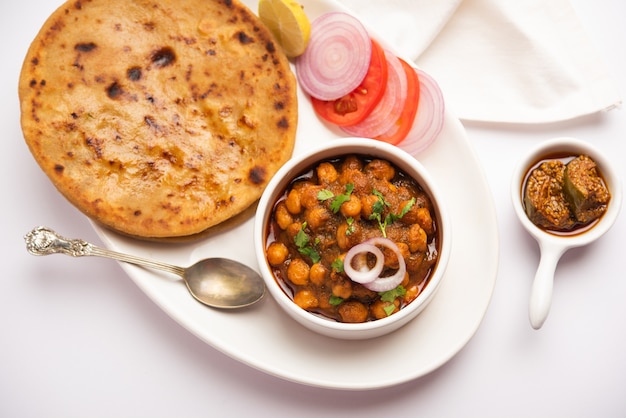 Chole con Aloo Paratha receta de comida popular del norte de la India servida caliente con pepinillo de mango