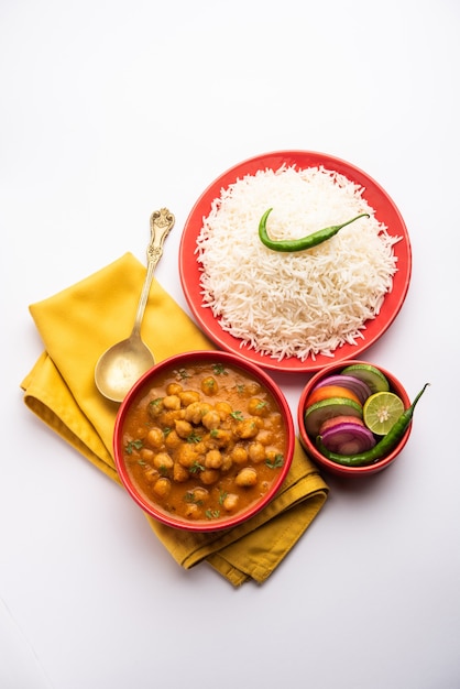 Chole chawal de comida india o curry picante de garbanzos con arroz simple servido con ensalada verde. enfoque selectivo