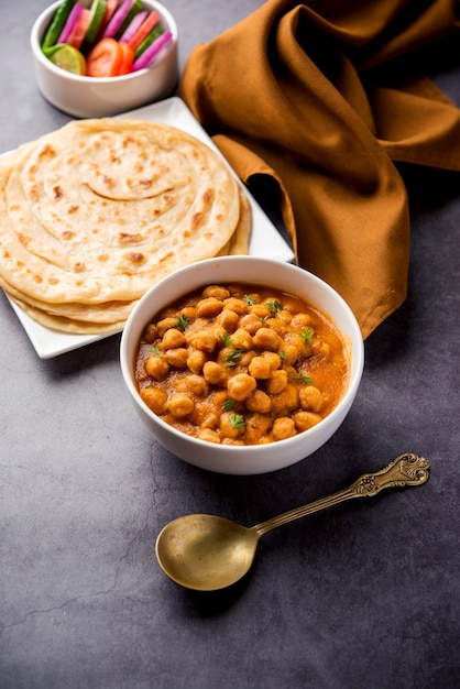 Chole oder Chana Masala mit Paratha, Kichererbsen-Scharf-Curry serviert mit Laccha Parantha