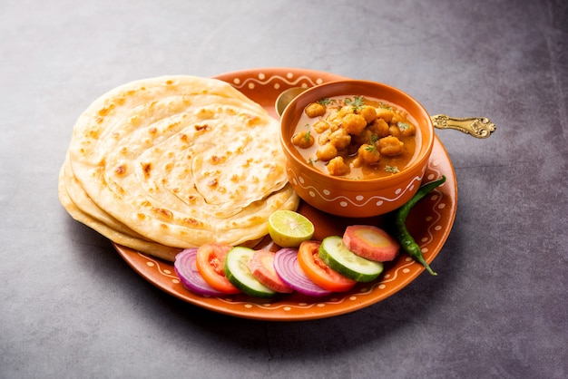 Chole oder Chana Masala mit Paratha, würziges Curry aus Kichererbsen, serviert mit Laccha Parantha. Beliebtes nordindisches Gericht