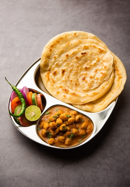 Chole oder Chana Masala mit Paratha, würziges Curry aus Kichererbsen, serviert mit Laccha Parantha. Beliebtes nordindisches Gericht