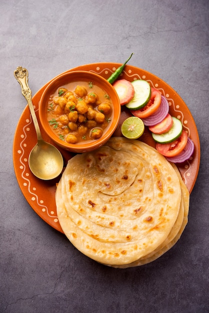 Chole ou Chana Masala com Paratha, curry picante de grão de bico servido com laccha parantha