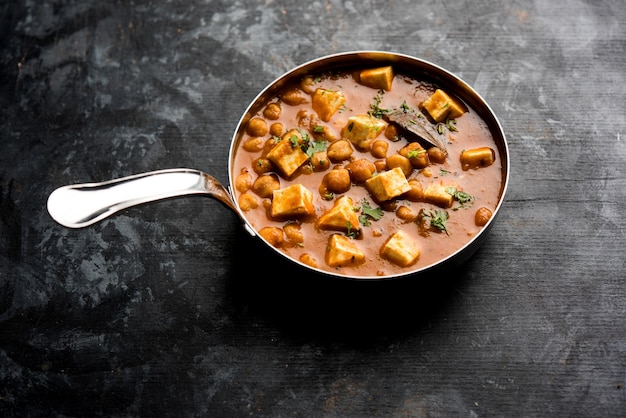 Chole Paneer Curry aus gekochter Kichererbse mit Hüttenkäse mit Gewürzen. Beliebtes nordindisches Rezept. in einer Schüssel oder Servierpfanne serviert. Selektiver Fokus