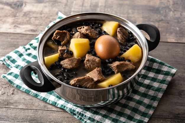 Cholent judaico tradicional em caçarola na mesa de madeira