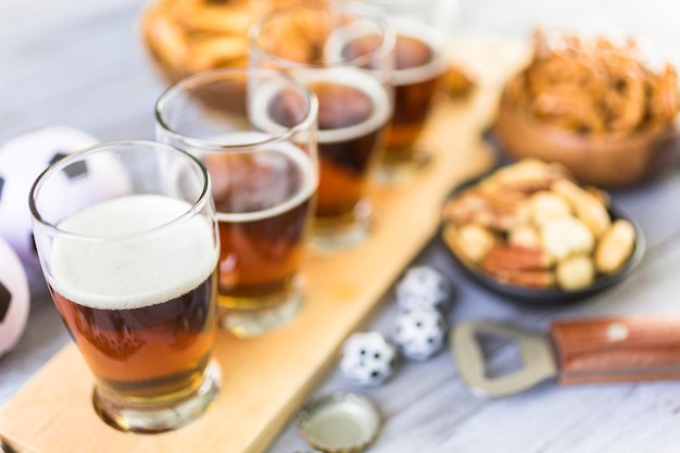 Chopes e salgadinhos em cima da mesa para festa de futebol.