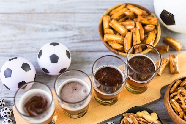 Chopes e salgadinhos em cima da mesa para festa de futebol.