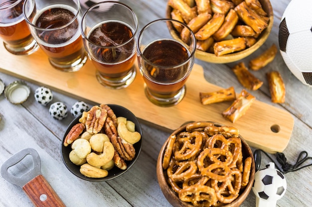 Chopes e salgadinhos em cima da mesa para festa de futebol.