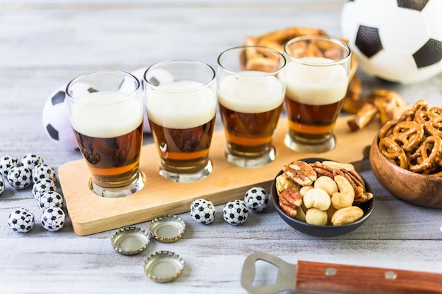 Chopes e salgadinhos em cima da mesa para festa de futebol.