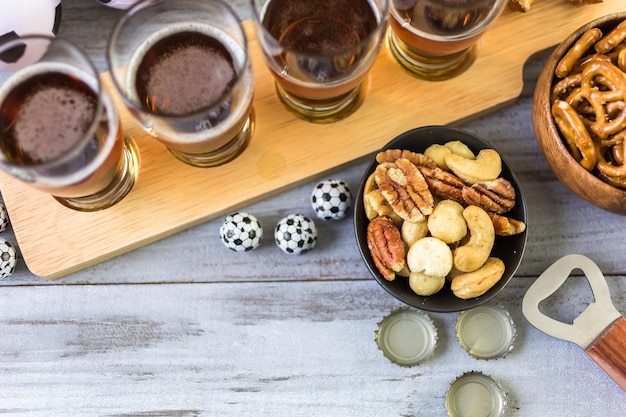 Chopes e salgadinhos em cima da mesa para festa de futebol.